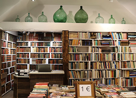 Vista de una estantería llena de libros y de un expositor con más libros