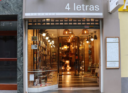 Vista exterior de la entrada de la librería, dónde se pueden ver los dos escaparates y, al fondo, un número cuatro iluminado