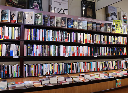 Vista de una estantería llena de libros y del expositor acoplado a la misma con más libros