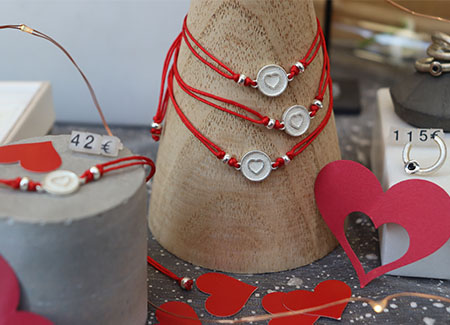 Expositor con varias pulseras de temática de San Valentín y anillos en un lateral