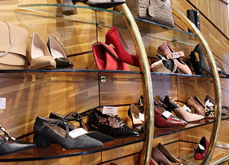 Vista del interior de la zapatería, dónde pdemos ver un expositor de pared con zapatos de mujer de diferentes estilos y colores