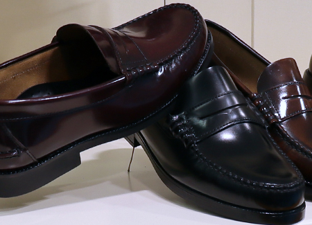 Primer plano de tres zapatos sin cordones para caballero, dos de color burdeos y uno de color negro