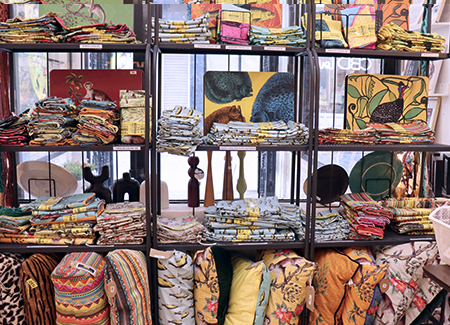 Una estantería con cojines y telas estampadas con colores alegres